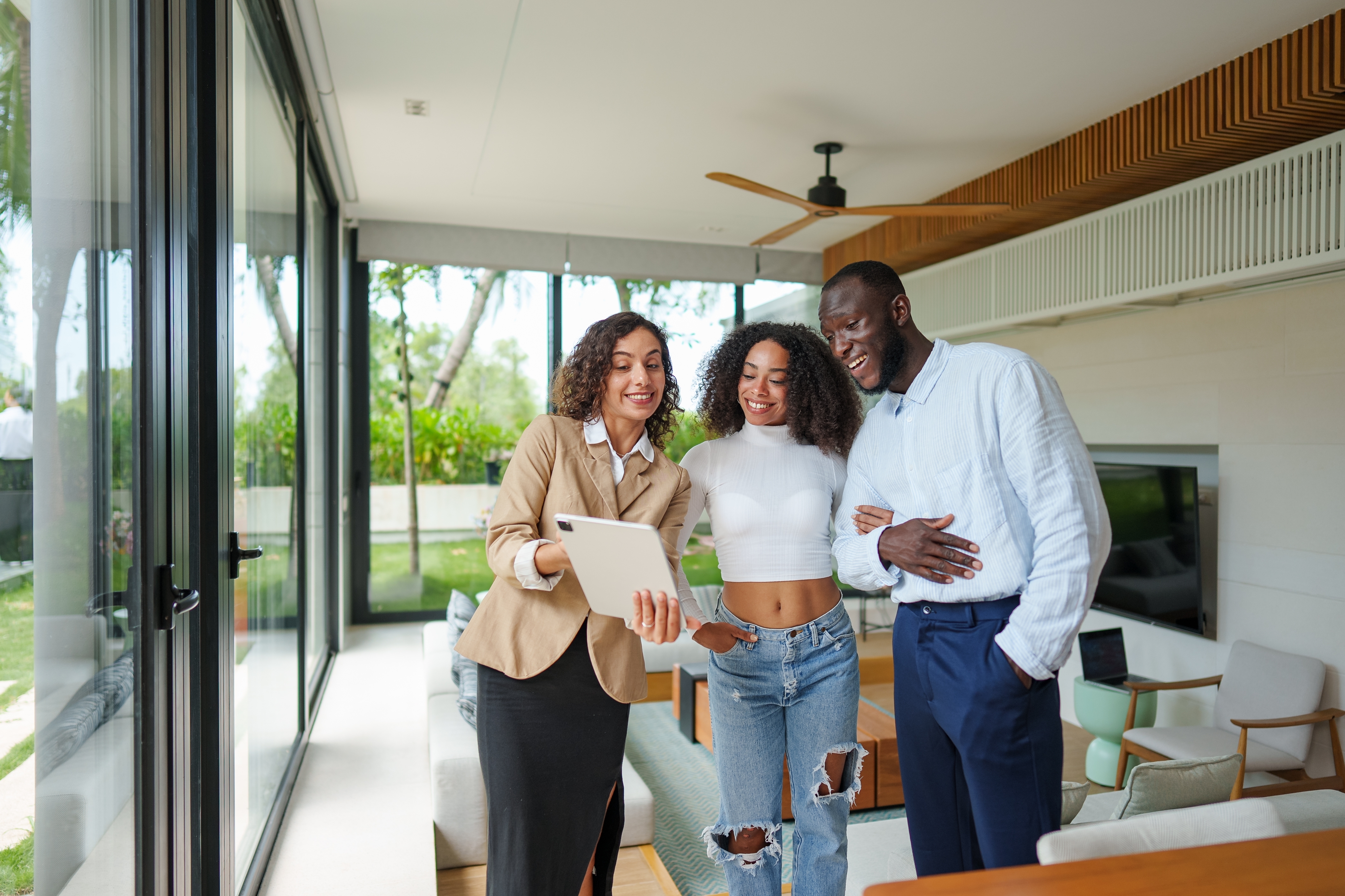 Agente inmobiliario muestra opciones de propiedad de lujo a pareja joven